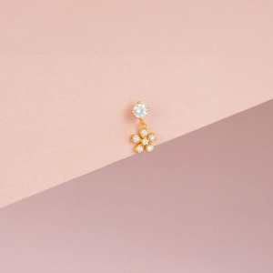 Détail macro d'une boucle d'oreille fleur plaquée or 14 carats avec zircons