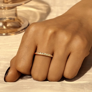 Nahaufnahme eines schmalen Goldrings mit Zirkonia-Steinen getragen am Zeigefinger