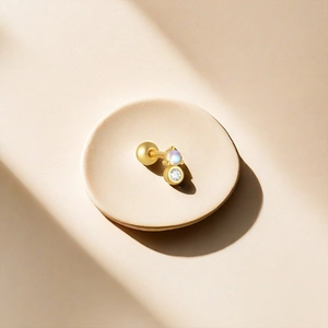 Détail macro d'une boucle d'oreille en argent S925 doré avec pierre de lune et zircon
