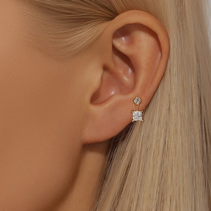 Gros plan de boucles d'oreilles en argent S925 doré avec zircons ronds et carrés