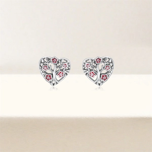 Détail de boucles d'oreilles cœur en argent S925 avec arbre de vie et fleurs en émail