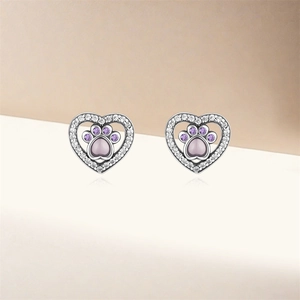 Détail de boucles d'oreilles cœur en argent s925 avec pierres patte violettes et zircons