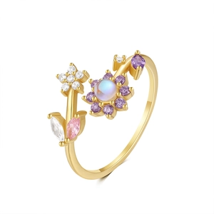 Close-up of golden adjustable ring with purple flower and zircon star details