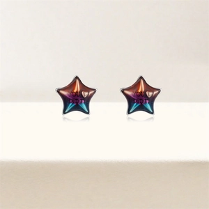Détail de boucles d'oreilles étoiles argentées avec dégradé de couleurs et texte gravé