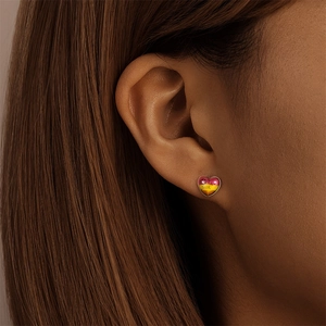 Gros plan d'une boucle d'oreille cœur avec dégradé rose et texte have faith