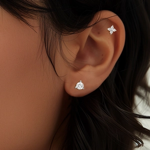 Dettaglio macro del piercing all'orecchio in argento S925 con corona di fiori in zirconi