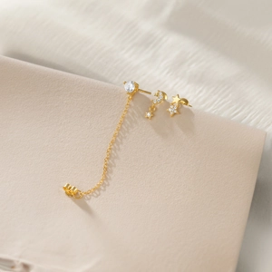 Macro detail of S925 sterling silver gold earrings with stars and moon zircon charms
