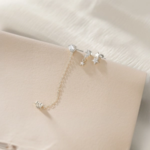 Detailed view of silver S925 moon and star earring set with zircon chain connector