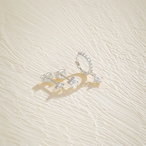 Macro detail of S925 sterling silver four-petal flower earrings with zircon pavé accents