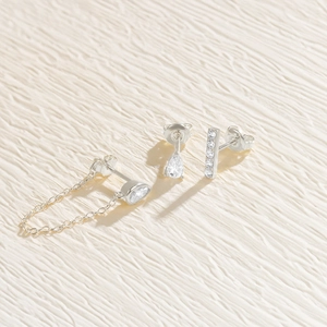 Detail of S925 silver earring set with pear-cut zircon studs and hanging chain link