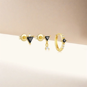 Detail of three-piece gold-plated earring set with black stones and clear zircon crystals
