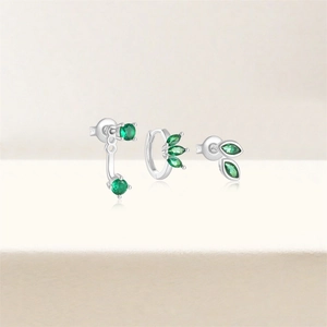 Macro detail of S925 sterling silver earrings set with sparkling green emerald zircons