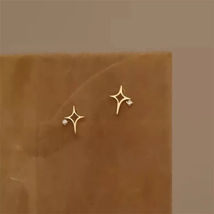 Detail von goldenen vierzackigen Sternohrringen mit Zirkonia-Inlay auf einer Displayplatte