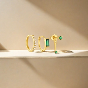 Detailed view of S925 silver gold-plated earring set with green emerald and white diamonds