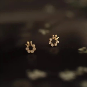 Detailansicht eleganter Kronen-Ohrstecker mit Zirkonia-Steinen und goldener Veredelung