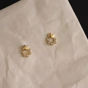 Nahaufnahme eleganter goldener Kronen-Kranz-Ohrstecker mit weißen Zirkoniasteinen