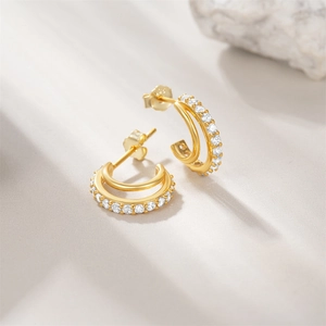 Macro shot of S925 sterling silver C-shaped hoop earrings with gold plating and zircons