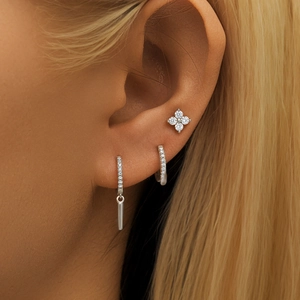 Nahaufnahme eines s925 Silber Ohrring-Sets mit floralen und geometrischen Diamant-Designs