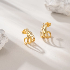 Detail view of gold S925 sterling silver three-row curved earrings with white cubic zirconia