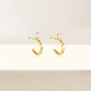 Detail of gold-plated J-shaped earrings with sparkling marquise-cut zircon stones