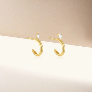 Detailed view of gold-plated geometric C-shape earrings with marquise-cut zircon stones