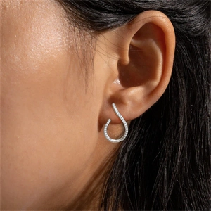 Close-up of S925 sterling silver geometric drop earring with pavé zircon stones on ear