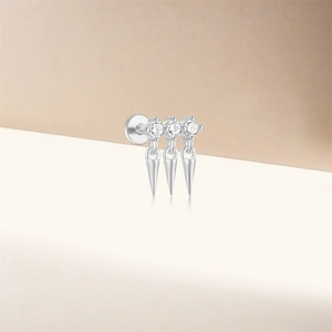 Détail d'un piercing d'oreille en argent S925 avec trois zircons et pendentifs coniques