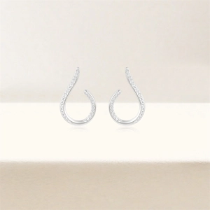 Detailed view of silver drop earrings featuring geometric openwork and pave set crystals