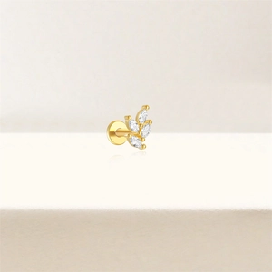 Vue macro d'un piercing d'oreille feuille dorée avec zircons en coupe marquise