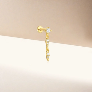 Détail d'un clou d'oreille en argent 925 avec pendentif goutte en zircon doré