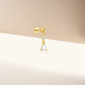 Vue macro d'une boucle d'oreille labret S925 dorée avec diamant poire et pierre ronde