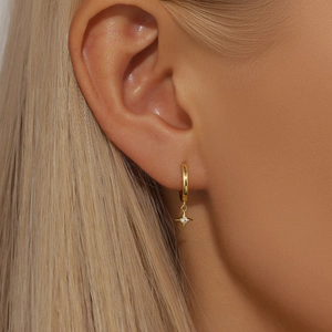 Detailed view of a gold plated S925 sterling silver hoop earring with star pendant