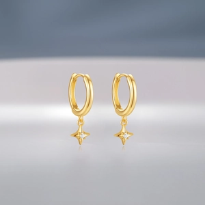 Macro shot of gold S925 sterling silver hoop earrings with diamond North Star charms