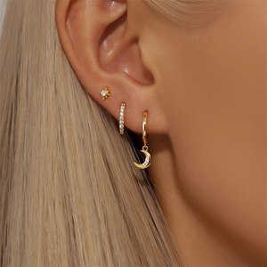 Detailed view of 925 silver gold star and moon earring set on model with zircon inlay
