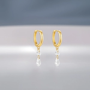 Detail of gold hoops featuring brilliant round and teardrop crystal pendants