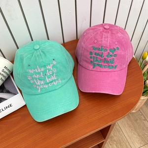 Vintage washed cotton baseball caps with floral embroidery in mint green and rose pink colors