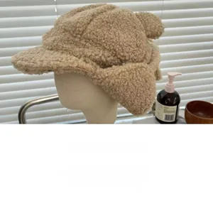 Detail of beige faux shearling aviator hat showing warm curly wool texture and ear flaps