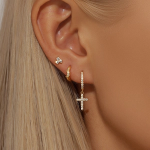 Detail of s925 silver flower and star earring set with gold finish and zirconia