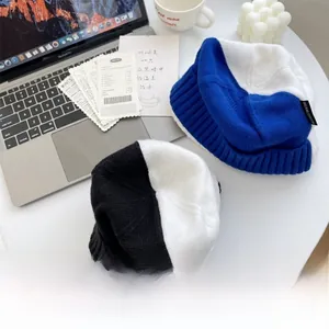 Détail du bonnet en maille bleu et blanc avec étiquette de marque sur une table