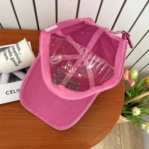 Detailed interior of a deep pink cotton baseball cap with embroidery and adjustable buckle