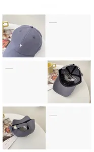 Detail of grey-blue baseball cap featuring white Y embroidery and metal back buckle