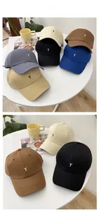 Close-up of baseball caps in six colors with embroidered letter Y on a white table