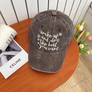 Macro view of embroidered inspirational quote on washed cotton dark grey baseball cap