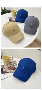 Detail view of cotton baseball caps with Y embroidery in khaki, blue and grey colors