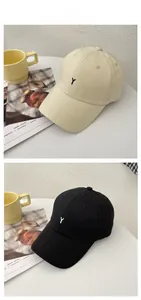 Detailed tile display of beige and black cotton baseball caps with Y embroidery
