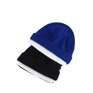 Bonnets en maille bleu et noir avec revers côtelés blancs sur un fond blanc