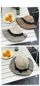 Detail of straw sun hat featuring black polka dot mesh brim and elegant bow decoration