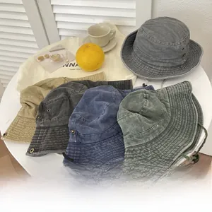 Close-up of assorted vintage washed canvas bucket hats with adjustable drawstrings