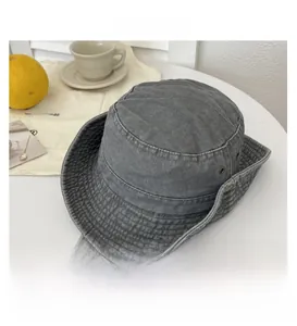 Detail of grey washed canvas bucket hat featuring metal eyelets and adjustable drawstring
