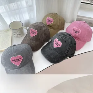 Close-up of heart embroidery on washed cotton baseball caps in multiple colors